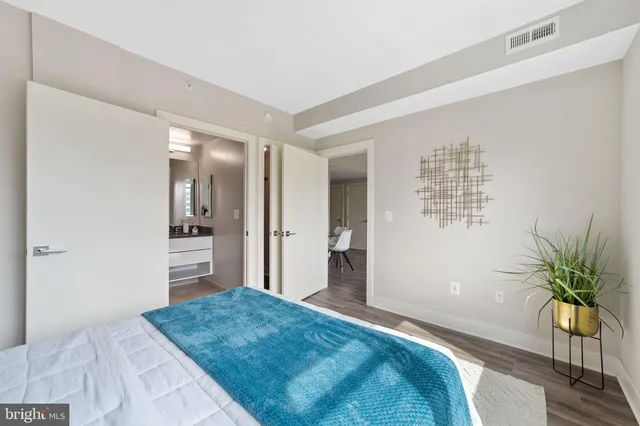 a bedroom with a bed and a potted plant