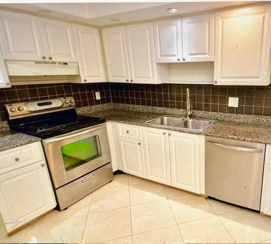 a kitchen with granite countertop white cabinets and white appliances