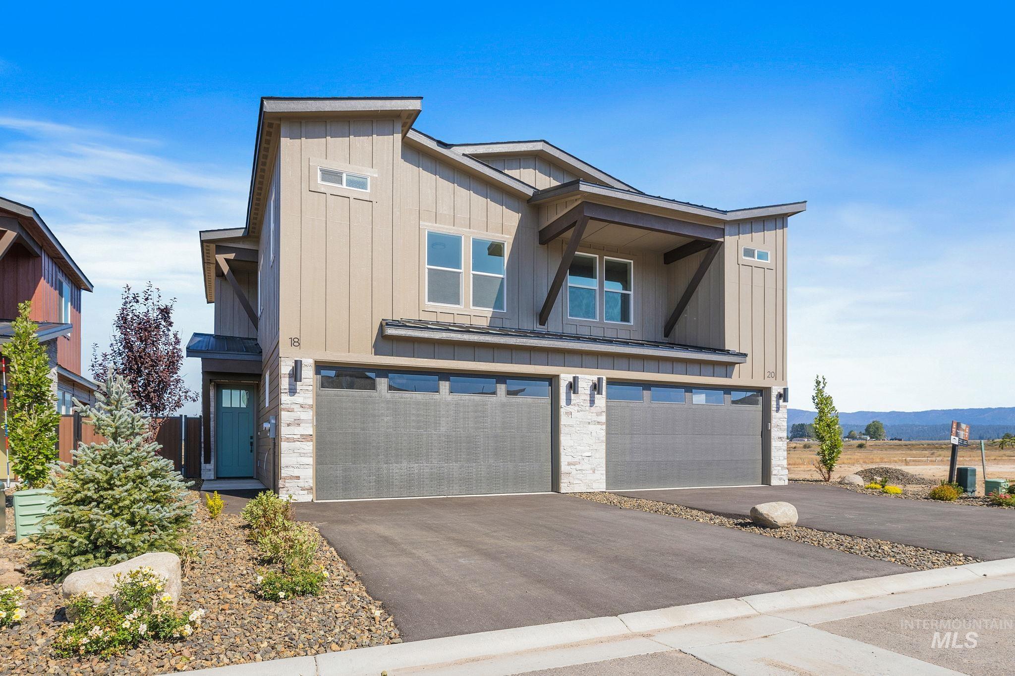 18 Ogden Street Cascade, ID 83611 - Photo 5 of 39 View of front of property with board and batten siding, a garage, asphalt driveway, stone siding, and a metal roof