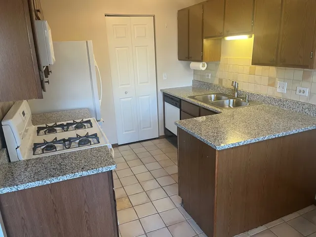 a kitchen with a sink a stove and a refrigerator