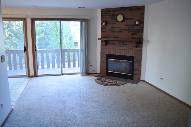 a view of an empty room with a fireplace and a window