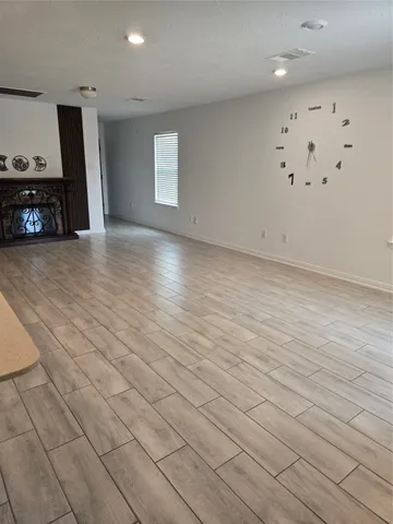 an empty room with wooden floor and a sink