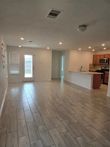 a view of empty room with wooden floor