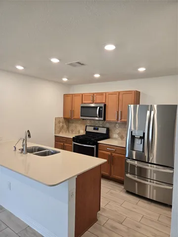 a kitchen with stainless steel appliances granite countertop a refrigerator and a stove