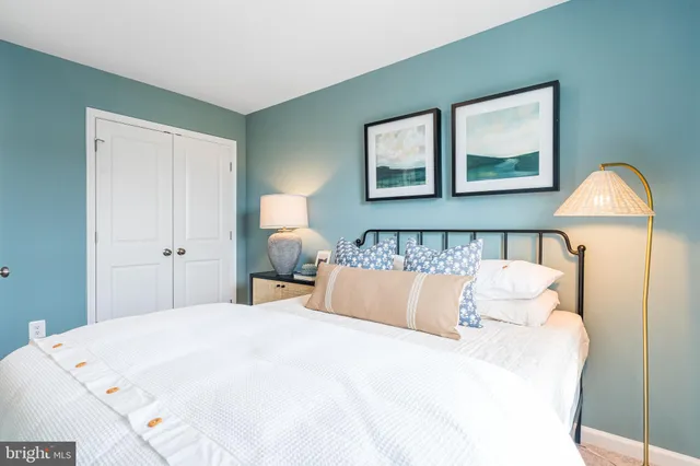 a bedroom with a bed and a painting on the wall