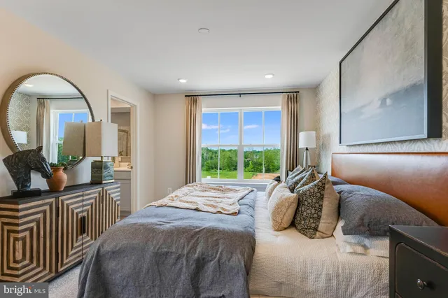 a bedroom with a bed a mirror and a large window