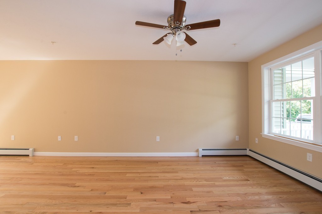 17 Arcade Street, Unit B Northbridge, MA 01588 - Photo 6 of 29 an empty room with wooden floor fan and windows