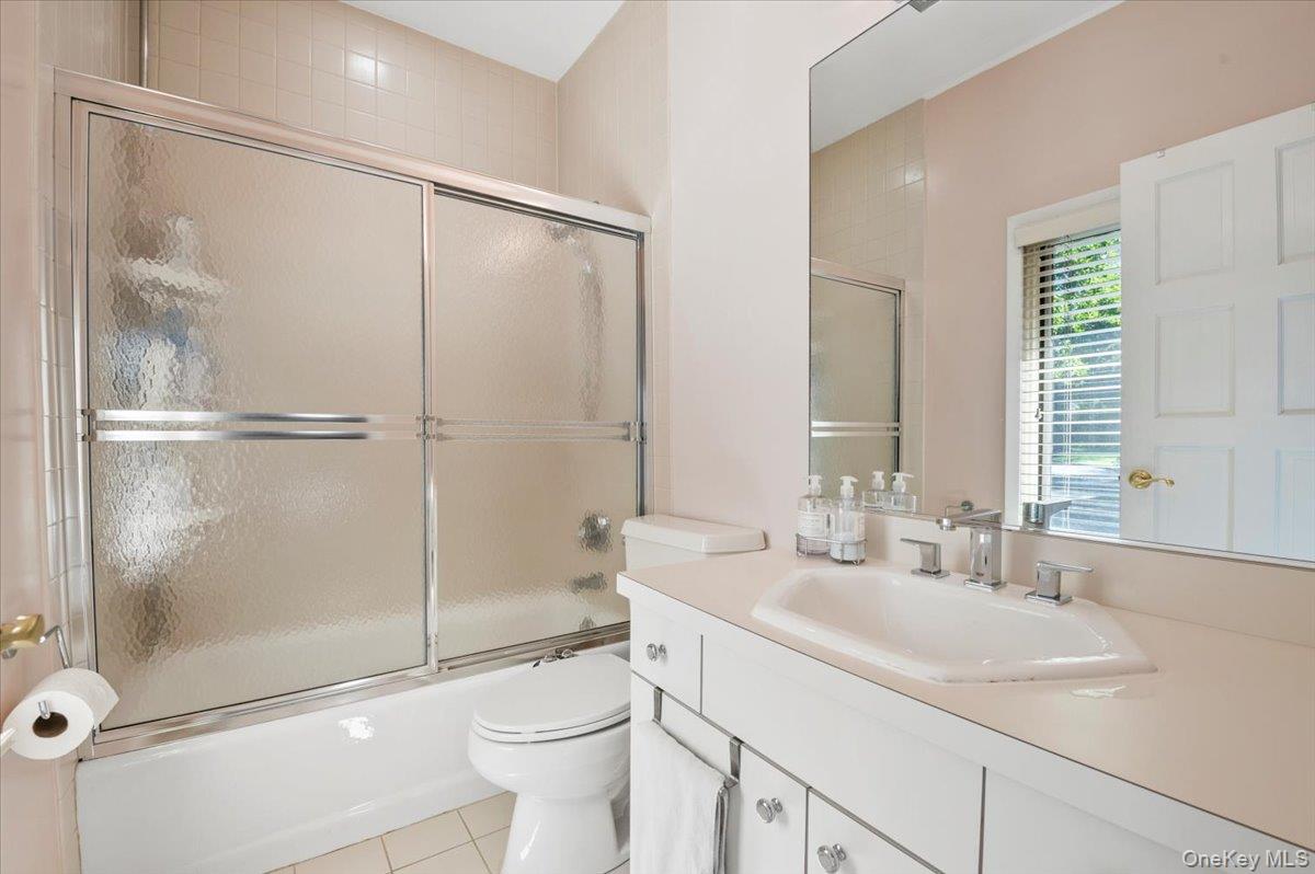 12 Ridge Court Glen Head, NY 11545 - Photo 28 of 46 Bathroom with enclosed tub / shower combo, vanity, and light tile patterned flooring