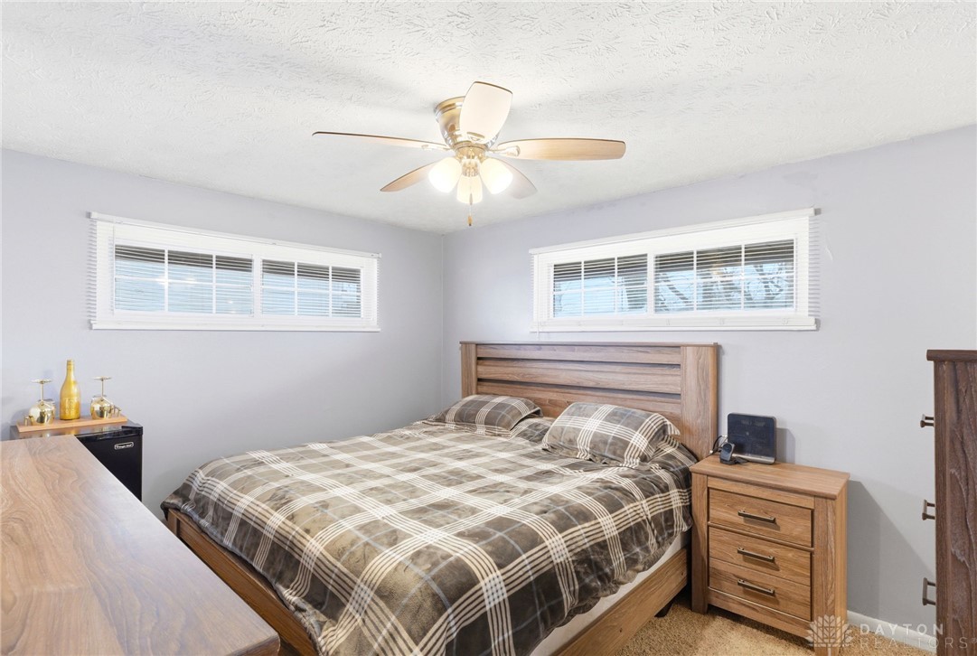 5171 Fishburg Road Dayton, OH 45424 - Photo 25 of 35 This cozy bedroom features warm wooden furnishings and ample natural light through its large windows.
