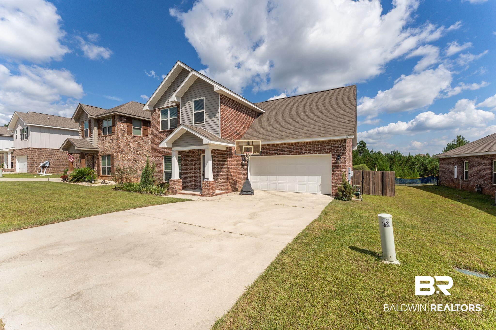 12711 Chickadee Lane Daphne, AL 36527 - Photo 3 of 39 View of front of house featuring brick siding, concrete driveway, a garage, and a shingled roof