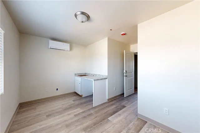 a view of a kitchen with white cabinets and wooden floor