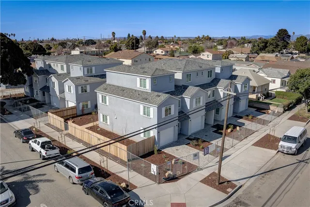 a view of a white house with iron fence