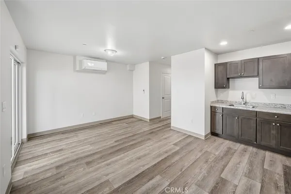 a view of a kitchen with wooden floor and electronic appliances
