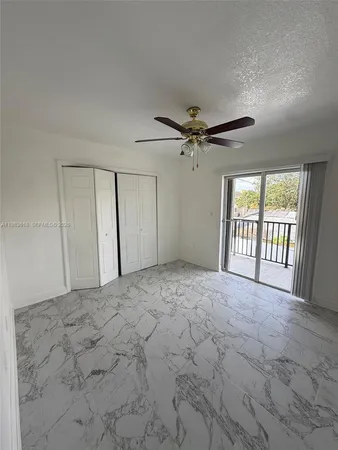 a view of a room with a ceiling fan and window