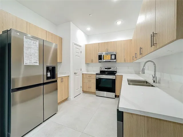 a kitchen with granite countertop a refrigerator stove and sink