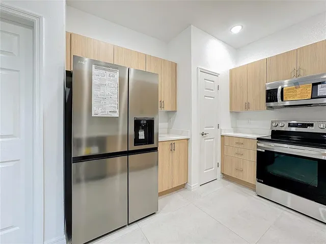 a kitchen with stainless steel appliances granite countertop a refrigerator and a stove top oven