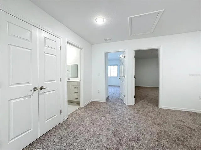 an empty room with closet and windows