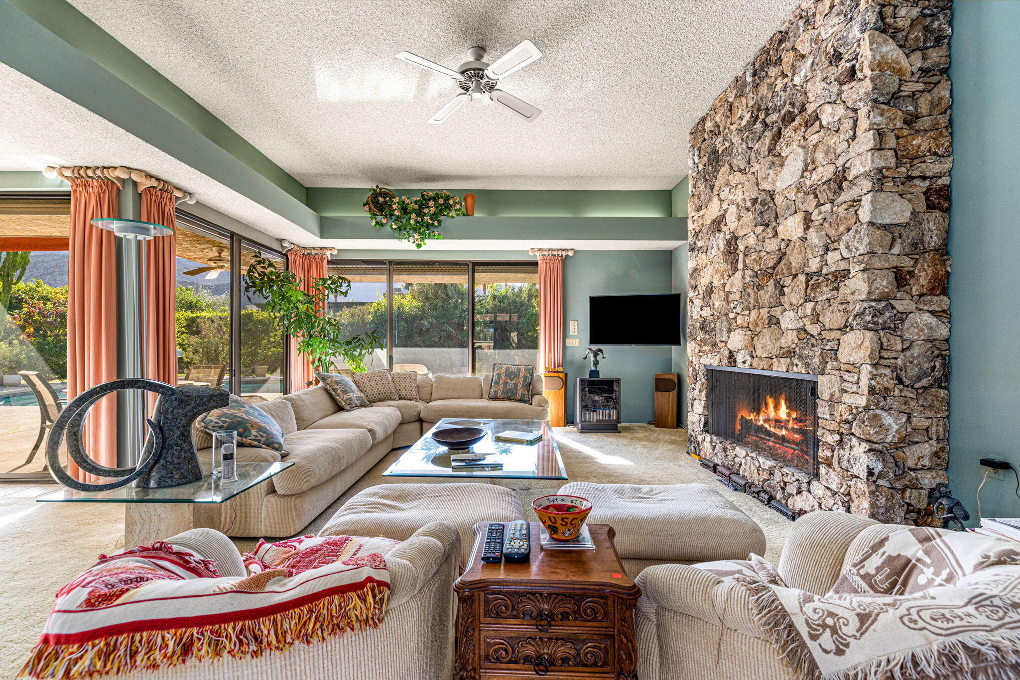 40675 East Thunderbird Terrace Rancho Mirage, CA 92270 - Photo 26 of 58 a living room with furniture a fireplace and a floor to ceiling window