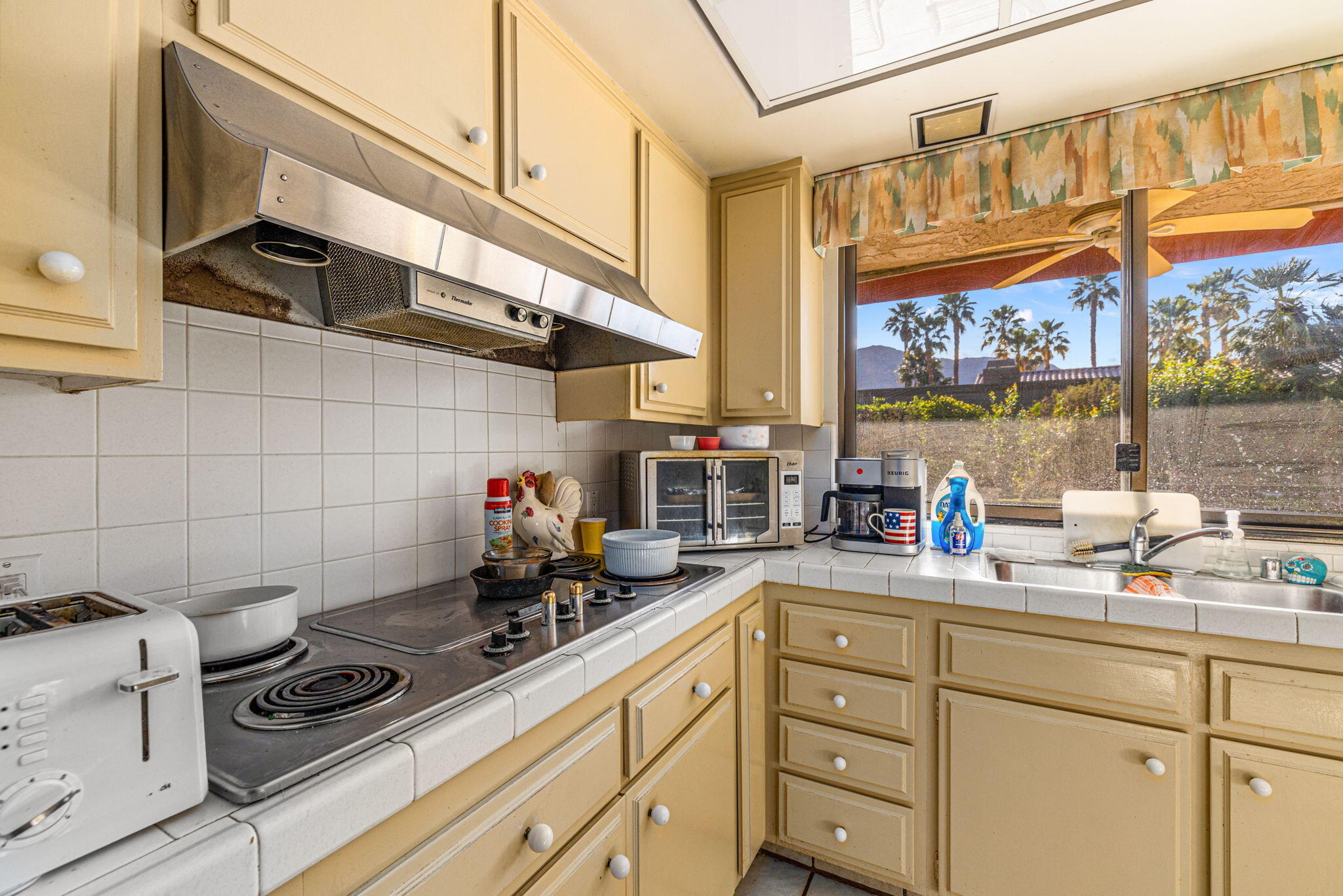 40675 East Thunderbird Terrace Rancho Mirage, CA 92270 - Photo 36 of 58 a kitchen with stainless steel appliances a sink a stove and a window