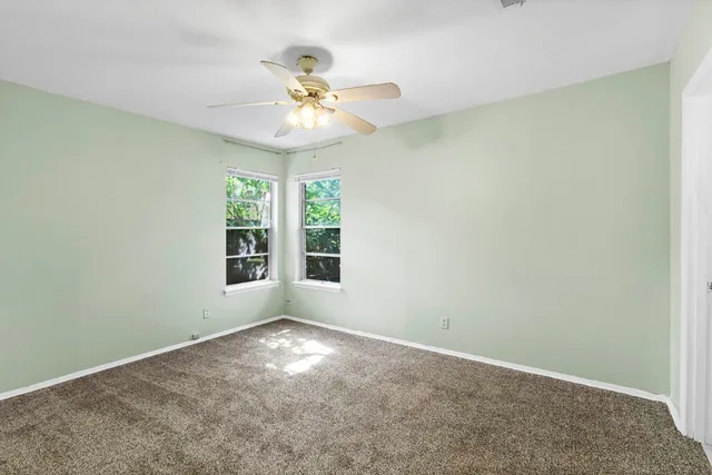 an empty room with a window and a fan