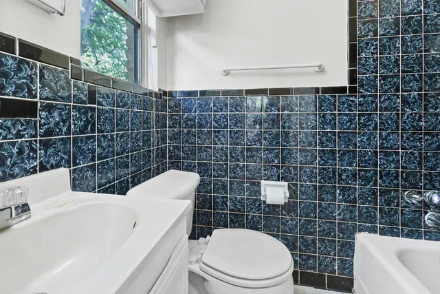 a bathroom with a toilet a sink and mirror