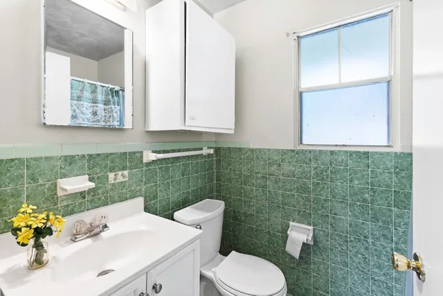 a bathroom with a sink mirror and toilet