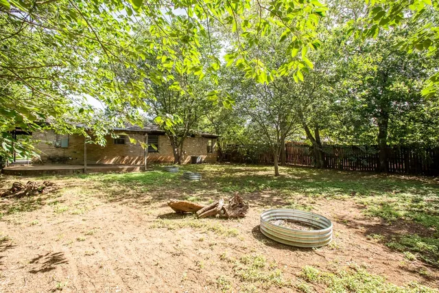 a view of a backyard with table and chairs and potted plants