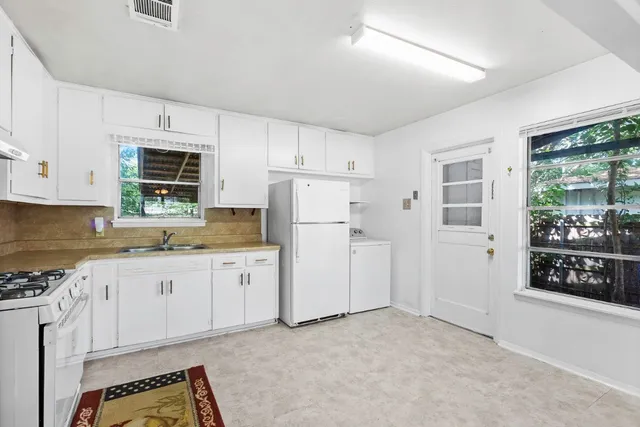 a kitchen with granite countertop white cabinets and refrigerator