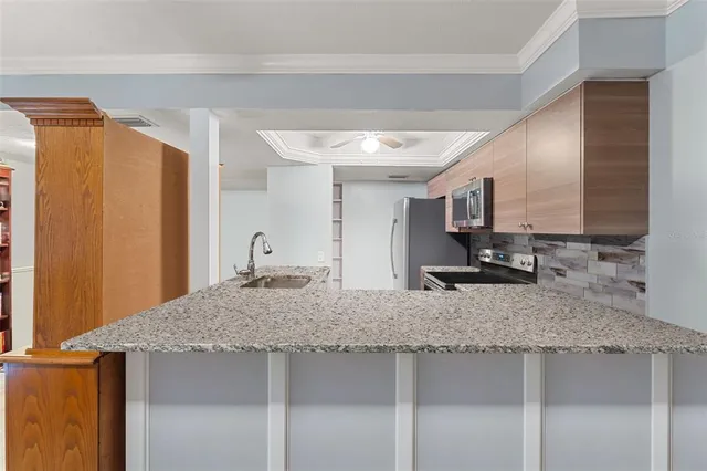 a kitchen with stainless steel appliances granite countertop a sink a stove and refrigerator