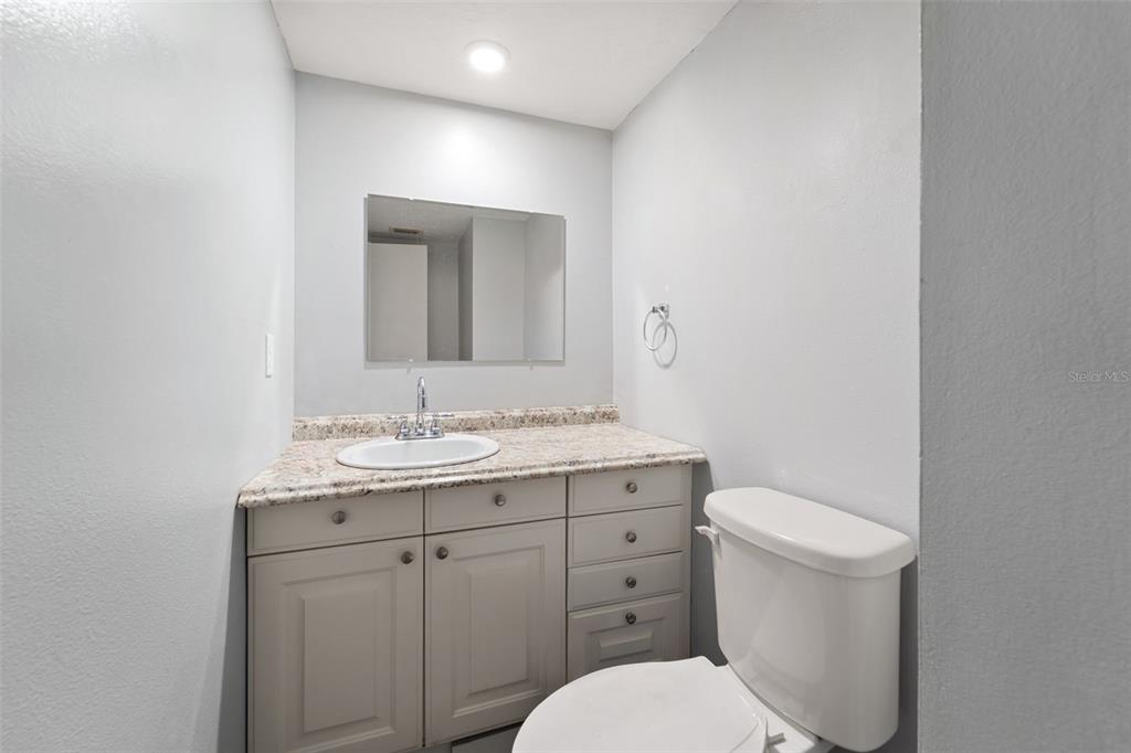 1112 Longfellow Road Sarasota, FL 34243 - Photo 24 of 48 a bathroom with a toilet a sink a vanity and mirror