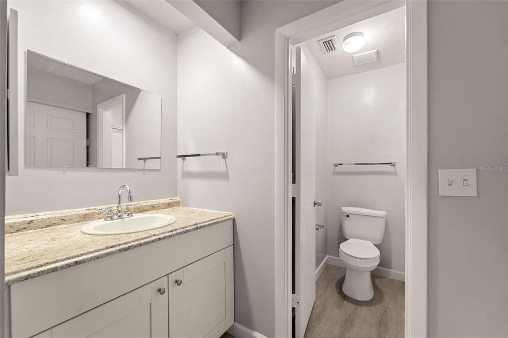 1112 Longfellow Road Sarasota, FL 34243 - Photo 29 of 48 a bathroom with a granite countertop sink a toilet and a mirror