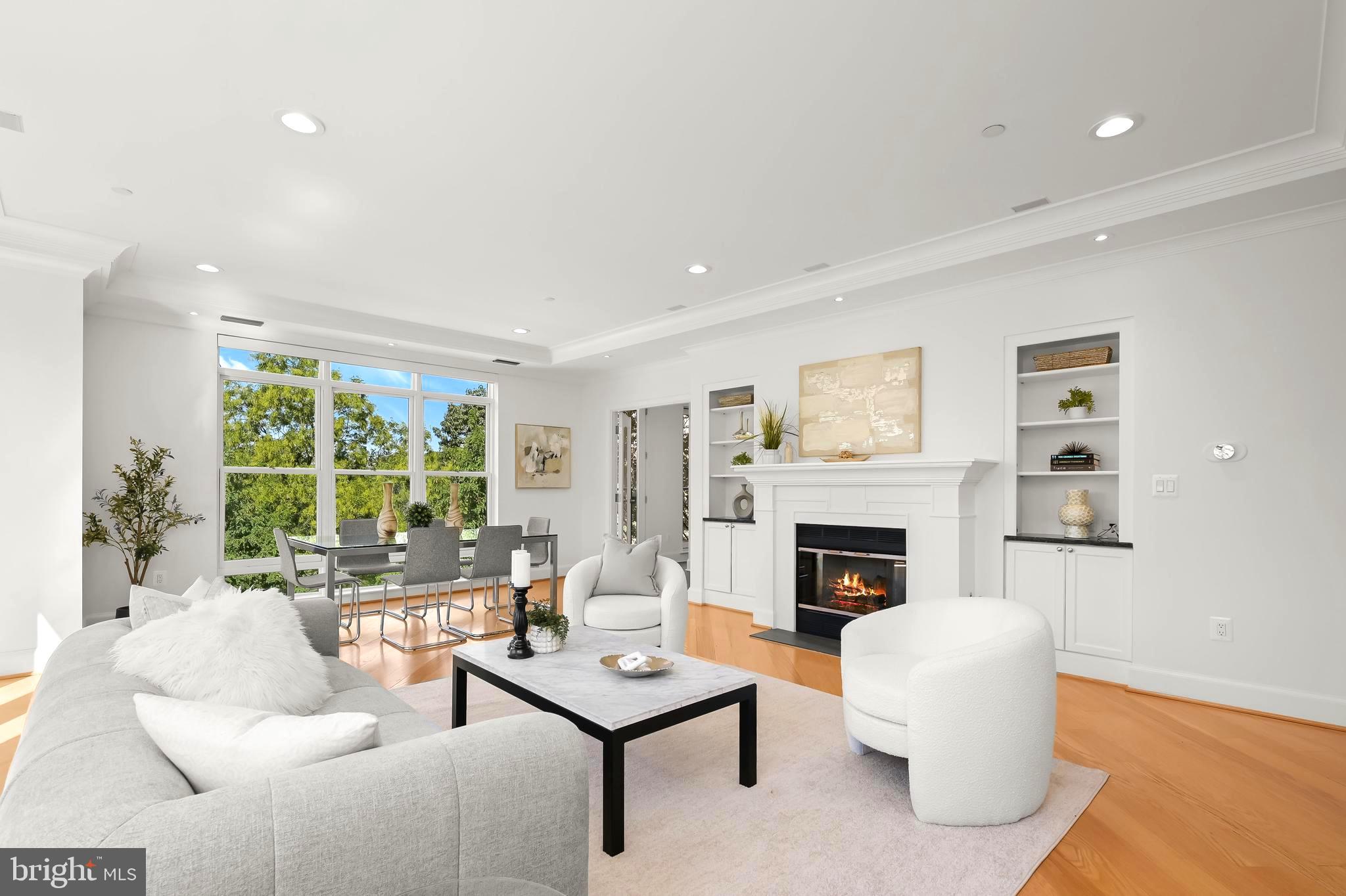 a living room with furniture fireplace and a large window