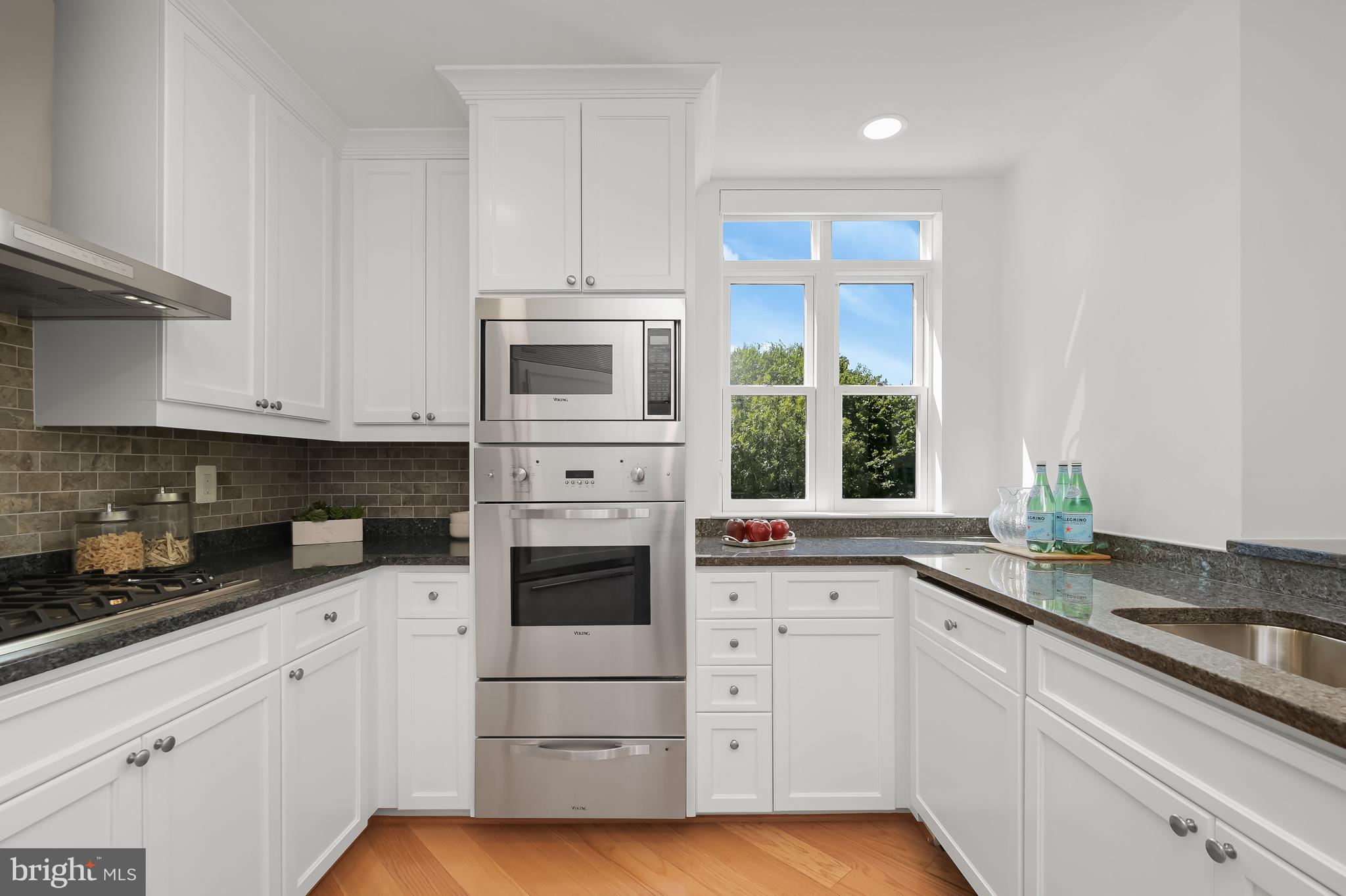 1414 22nd Street Northwest, Unit 41 Washington, DC 20037 - Photo 14 of 36 a kitchen with granite countertop white cabinets and white appliances