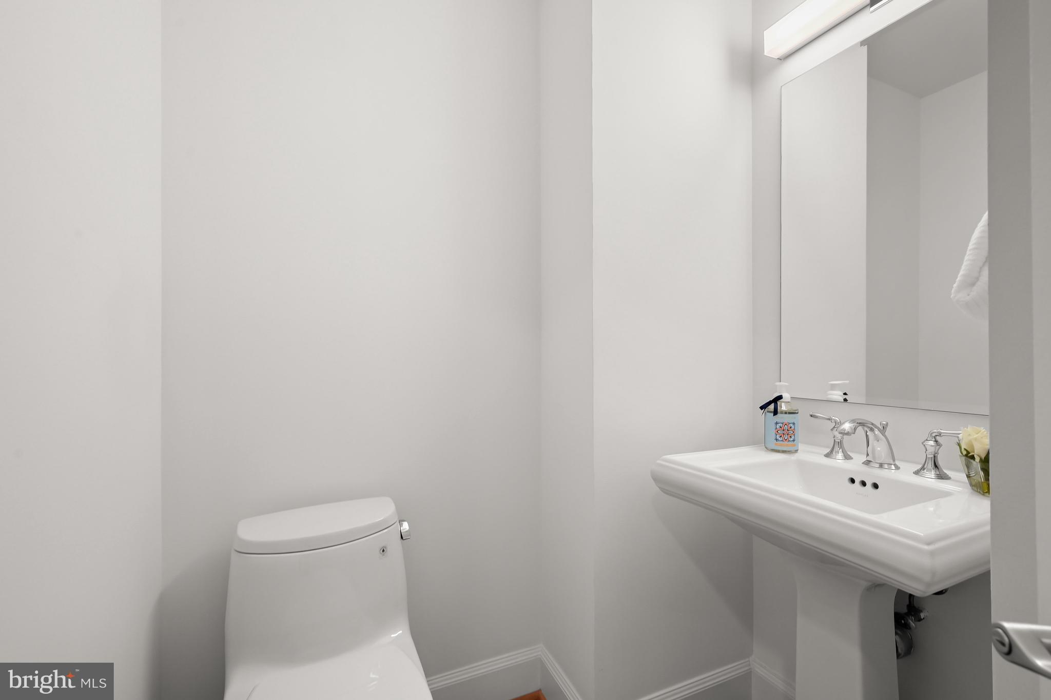 1414 22nd Street Northwest, Unit 41 Washington, DC 20037 - Photo 5 of 36 a bathroom with a sink a toilet and mirror