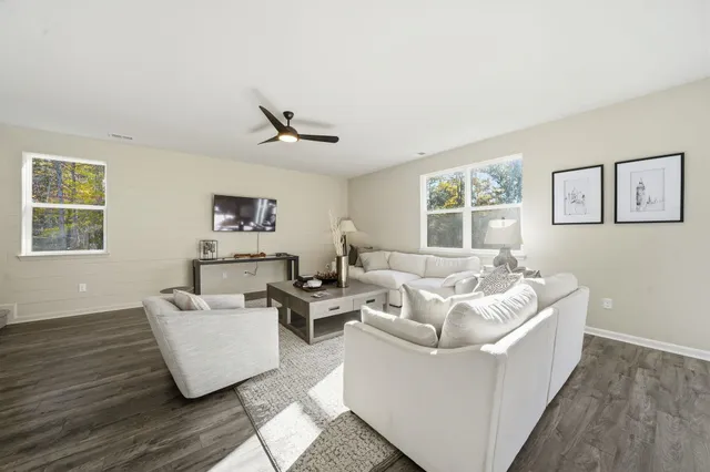 a living room with furniture and a wooden floor