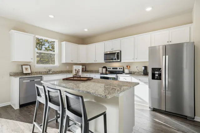 a open kitchen with kitchen island a sink table and chairs