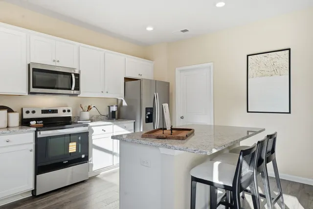 a kitchen with granite countertop white cabinets sink and stainless steel appliances