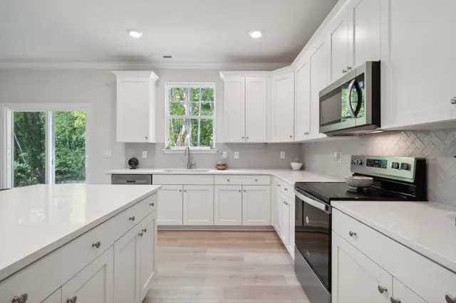 a kitchen with stainless steel appliances granite countertop a stove a sink and a microwave