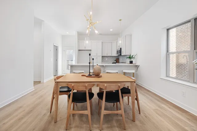 a dining room with a table chairs and kitchen view