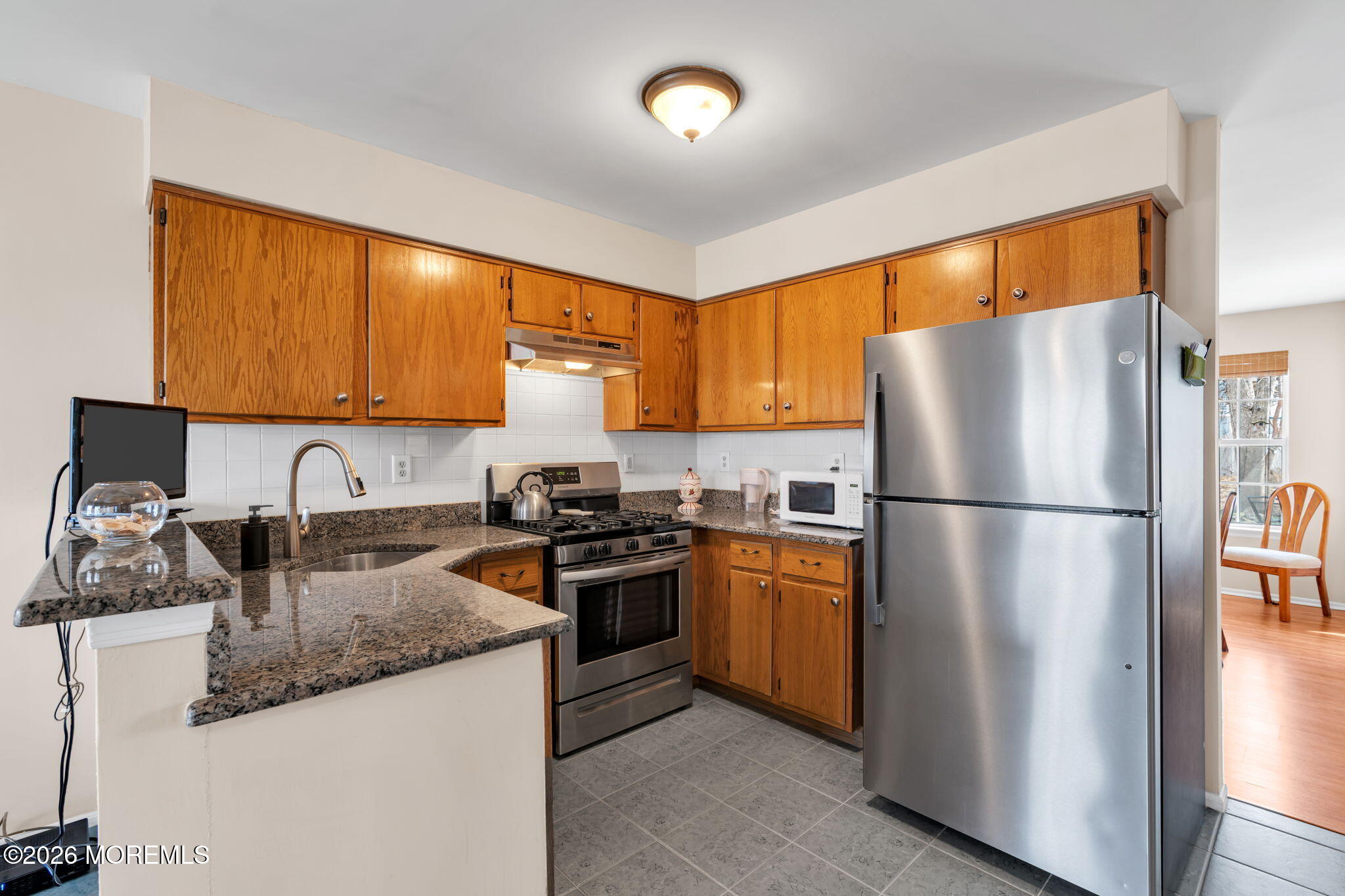 228 Moses Milch Drive Howell, NJ 07731 - Photo 13 of 26 a kitchen with granite countertop a refrigerator stove top oven a sink and dishwasher