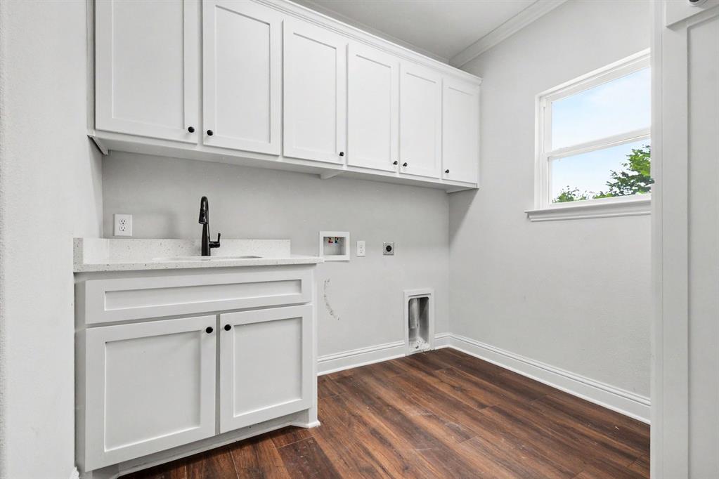530 P R 491 Leonard, TX 75452 - Photo 28 of 35 Dedicated utility space featuring white shaker cabinetry, a sink with a matte black faucet, and wood-finish flooring