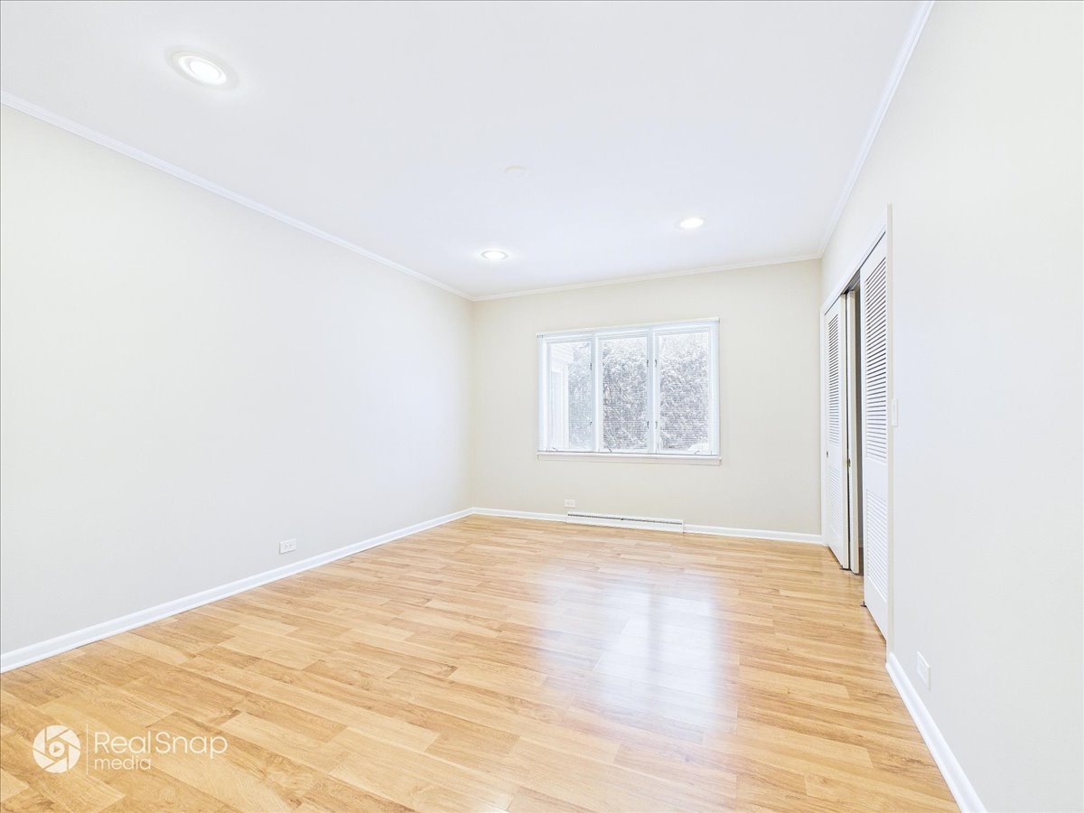 730 Sheridan Road Highland Park, IL 60035 - Photo 24 of 48 a view of an empty room with wooden floor and a window