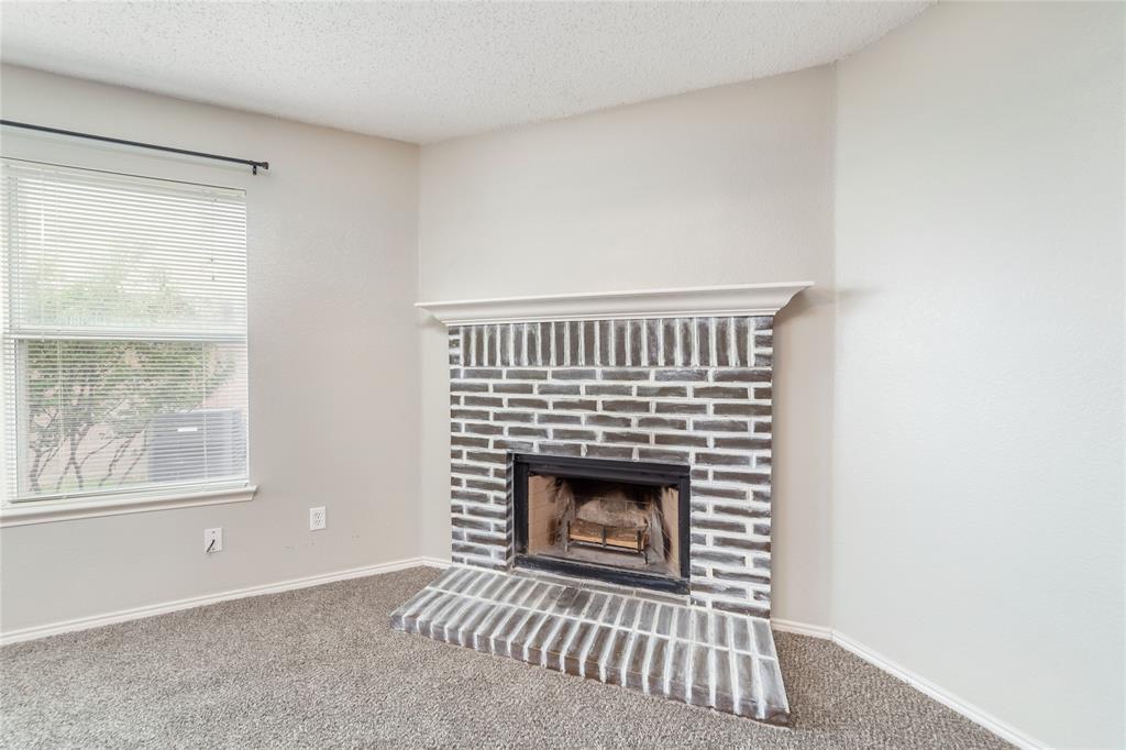 4408 Statesman Lane Fort Worth, TX 76244 - Photo 9 of 40 Interior details with carpet floors, a textured ceiling, and a fireplace