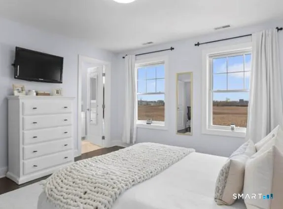a bedroom with a bed tv and a window
