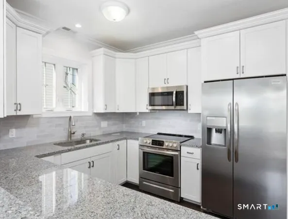 a kitchen with stainless steel appliances granite countertop a refrigerator sink and stove
