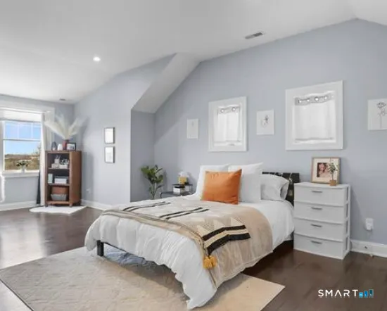 a bedroom with a large bed and a night stand