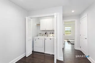 a view of a hallway with bathroom and wooden floor