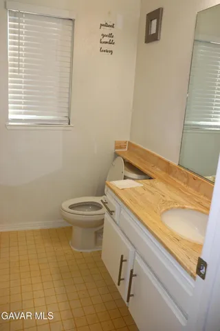 a bathroom with a granite countertop toilet and a sink
