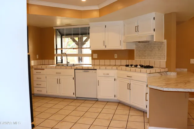 a kitchen with white cabinets appliances and a sink