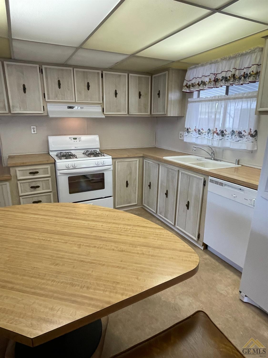 Undisclosed Address Bakersfield, CA 93308 - Photo 16 of 40 a kitchen with kitchen island a stove a sink and cabinets